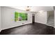 Open-concept living space with hardwood floors, staircase access, and large windows at 157 Jousters Ln, Lawrenceville, GA 30044