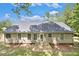 Back exterior featuring gray siding, a concrete patio, and multiple windows at 332 Christian Ln, Carrollton, GA 30116