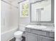 Well-lit bathroom with granite countertop, gray cabinets, and a combined tub and shower at 332 Christian Ln, Carrollton, GA 30116
