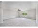 Expansive bedroom featuring a ceiling fan, neutral carpeting, and a large window at 332 Christian Ln, Carrollton, GA 30116