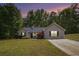 Charming single-story home with green lawn, trees and beautiful twilight sky at 332 Christian Ln, Carrollton, GA 30116