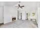 Spacious living room featuring a fireplace, ceiling fan, and entry to the kitchen at 332 Christian Ln, Carrollton, GA 30116