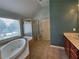 Bathroom with a large tub, glass shower, double sink vanity, and tiled flooring at 3943 Dunaire Dr, Stone Mountain, GA 30083