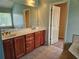 Bathroom featuring double sink vanity, large mirror, separate room, and tiled flooring at 3943 Dunaire Dr, Stone Mountain, GA 30083