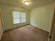 Cozy bedroom featuring neutral walls, plush carpeting, and a window providing natural light at 3943 Dunaire Dr, Stone Mountain, GA 30083