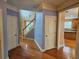 Hallway with hardwood floors leading to a staircase, multiple doorways, and kitchen at 3943 Dunaire Dr, Stone Mountain, GA 30083