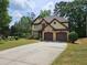 Charming two-story home with a well-manicured lawn and a two-car garage, complemented by mature trees at 3943 Dunaire Dr, Stone Mountain, GA 30083