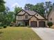 Charming two-story home with a well-manicured lawn and a two-car garage, complemented by lush landscaping at 3943 Dunaire Dr, Stone Mountain, GA 30083