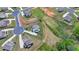 An aerial view shows a house situated on a large lot in a suburban neighborhood, featuring green spaces and cul-de-sacs at 3985 Foxdale Ln, Cumming, GA 30028