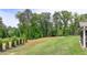 A spacious backyard with lush lawn, bordered by trees, and featuring a view of the home's screened-in porch at 3985 Foxdale Ln, Cumming, GA 30028