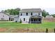 View of the home's backyard with a screened porch and patio at 3985 Foxdale Ln, Cumming, GA 30028