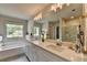 This bathroom features a double vanity, free standing soaking tub, and a large picture window for natural light at 3985 Foxdale Ln, Cumming, GA 30028