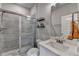 Bathroom with a gray tiled shower, toilet, large mirror, and a white sink at 3985 Foxdale Ln, Cumming, GA 30028