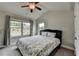 Bedroom with a ceiling fan, large window, and floral patterned quilt on the bed at 3985 Foxdale Ln, Cumming, GA 30028