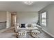 Bonus room with comfortable sofa, stylish poufs, and ample natural light from the window at 3985 Foxdale Ln, Cumming, GA 30028