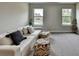 Bonus room with stylish couch, comfortable poufs, and windows bringing in natural light at 3985 Foxdale Ln, Cumming, GA 30028