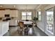 Bright dining area with hardwood floors, round wooden table, and modern chandelier near the kitchen and patio doors at 3985 Foxdale Ln, Cumming, GA 30028