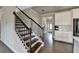 Entryway with hardwood floors, white walls, stairs with black metal railing, and kitchen cabinets at 3985 Foxdale Ln, Cumming, GA 30028