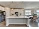 Bright kitchen features white cabinets, stainless appliances, large center island, pendant lights, and eat-in dining at 3985 Foxdale Ln, Cumming, GA 30028