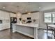 Modern kitchen with white cabinets, stainless steel appliances, large island, and pendant lights over hardwood floors at 3985 Foxdale Ln, Cumming, GA 30028