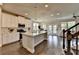 Open-concept kitchen with white cabinets, stainless steel appliances, quartz countertops, and hardwood floors at 3985 Foxdale Ln, Cumming, GA 30028