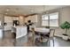 Open kitchen and dining area with white cabinets, stainless steel appliances, pendant lights over the island, and hardwood floors at 3985 Foxdale Ln, Cumming, GA 30028