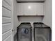 This laundry room features cabinets for storage and gray front-loading washer and dryer at 3985 Foxdale Ln, Cumming, GA 30028