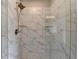 This shower features a glass enclosure and is tiled with gray and white marble-look tile at 3985 Foxdale Ln, Cumming, GA 30028