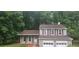 Charming two-story home features an attached two-car garage, gray siding, and mature trees at 991 Park Creek Cir, Lawrenceville, GA 30044