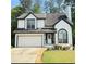 Charming two-story home boasts a manicured lawn, attached garage, and inviting curb appeal at 210 Paris Dr, Lawrenceville, GA 30043