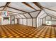 Bright attic space featuring exposed wood beams, paneled walls, and unique flooring, offering potential for creative customization at 4716 N Springs Ct, Atlanta, GA 30338