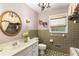 Stylish bathroom with a decorative mirror, a chandelier, green tile, and decorative wallpaper, showcasing a charming design at 4716 N Springs Ct, Atlanta, GA 30338