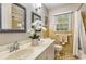 Bathroom featuring a double vanity, decorative mirrors, and bright lighting at 4716 N Springs Ct, Atlanta, GA 30338
