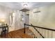 Hallway with hardwood floors leading to a bathroom; features overhead lighting and stair access at 4716 N Springs Ct, Atlanta, GA 30338