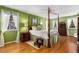 Four-poster bed in a sunlit bedroom with green walls, hardwood floors, and coordinated décor at 4716 N Springs Ct, Atlanta, GA 30338