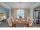 Formal dining room featuring an elegant chandelier, large windows, and seating for eight at 589 Arbor Ridge Dr, Stone Mountain, GA 30087