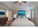 Comfortable main bedroom with a ceiling fan, a tray ceiling, and a large bed with blue ocean art above it at 589 Arbor Ridge Dr, Stone Mountain, GA 30087