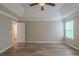 This main bedroom has gray-colored walls, light-colored floors, and a tray ceiling with a ceiling fan at 589 Arbor Ridge Dr, Stone Mountain, GA 30087