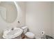 Cozy bathroom features a pedestal sink and a stylish round mirror at 3800 Market Walk, Clarkston, GA 30021