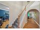 Bright foyer features hardwood floors, staircase with wooden banister, and arched entryway at 3800 Market Walk, Clarkston, GA 30021