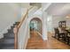 Bright foyer features hardwood floors, staircase with wooden banister, and arched entryway at 3800 Market Walk, Clarkston, GA 30021