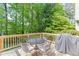 Back deck featuring a wood railing, chairs, and table under a canopy of trees at 900 Meadowsong Cir, Lawrenceville, GA 30043