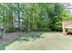 Expansive backyard with lush greenery, mature trees, and play structure at 900 Meadowsong Cir, Lawrenceville, GA 30043