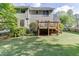 Back exterior of home featuring a wood deck overlooking green lawns and a privacy fence at 900 Meadowsong Cir, Lawrenceville, GA 30043