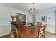 Open dining area adjacent to the living room, illuminated by a chandelier, with seating for six and elegant decor at 900 Meadowsong Cir, Lawrenceville, GA 30043