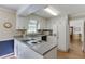 Traditional-style kitchen with white cabinets, black appliances, and view to hallway at 900 Meadowsong Cir, Lawrenceville, GA 30043