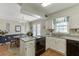 Traditional-style kitchen with white cabinets, black appliances, breakfast nook, and view to the deck at 900 Meadowsong Cir, Lawrenceville, GA 30043