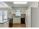 Traditional-style kitchen with white cabinets, black appliances, and a view to the deck at 900 Meadowsong Cir, Lawrenceville, GA 30043