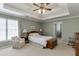 Relaxing main bedroom with a tray ceiling, chair, and ample natural light at 900 Meadowsong Cir, Lawrenceville, GA 30043