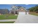 Beautiful two-story home with a stone facade, manicured lawn, and a three-car garage on a sunny day at 307 Ernest Ave, Peachtree City, GA 30269